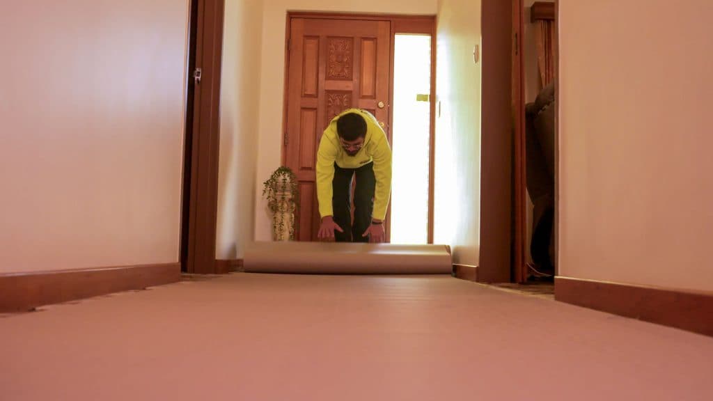 Removalist laying the protective covering on a floor